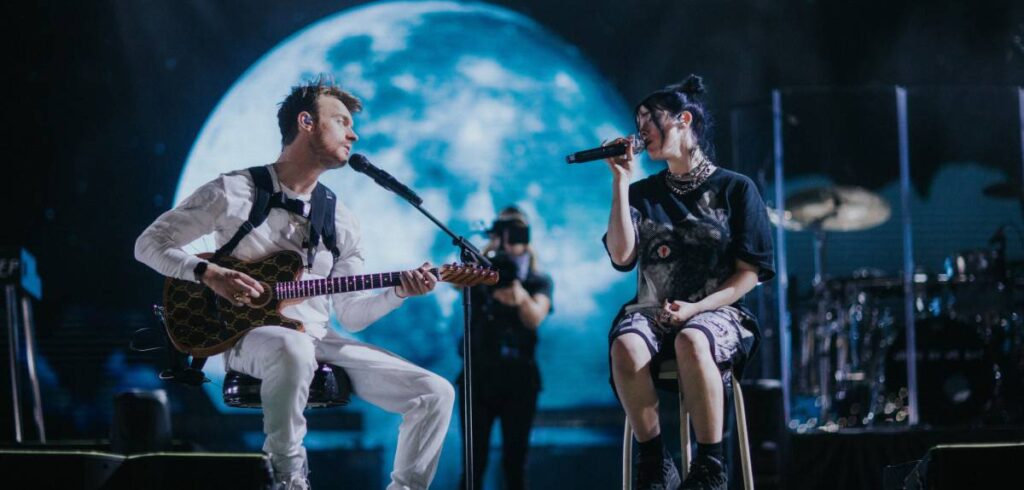 Billie Eilish and Finneas O’Connell on stage in “Billie Eilish: The World’s A Little Blurry,” premiering globally February 26, 2021 on Apple TV+.