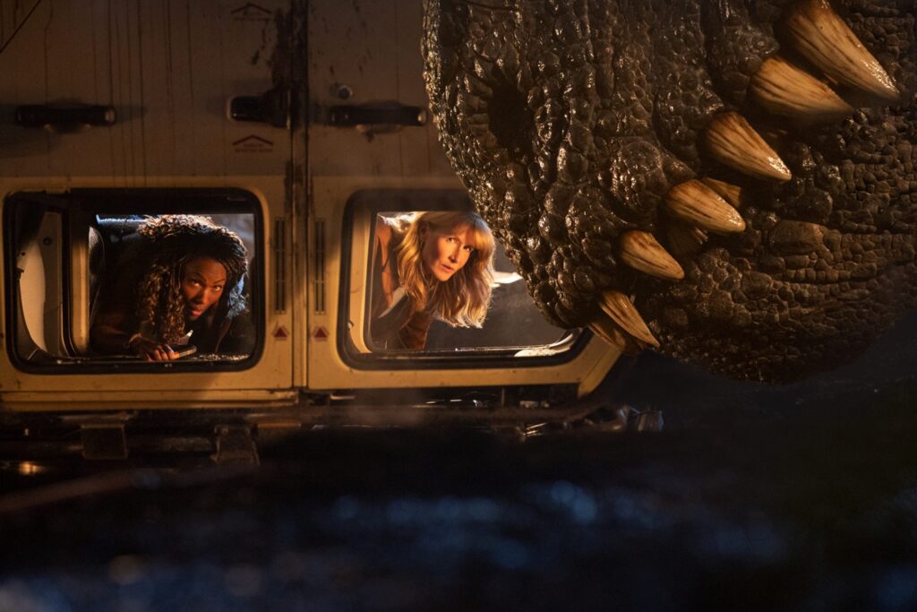 (from left) Kayla Watts (DeWanda Wise), Dr. Ellie Sattler (Laura Dern) and a Giganotosaurus in Jurassic World Dominion, co-written and directed by Colin Trevorrow.